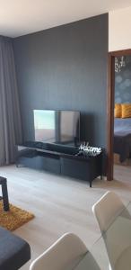 uma sala de estar com televisão e uma cama em GalériusPrémium6 em Siófok