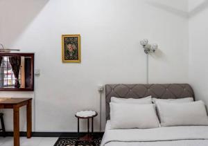 Cette chambre blanche comprend un lit et une table. dans l'établissement Shah Alam Golden Homestay 4 Rooms, 3 Bathrooms Seksyen 7 near uitm icity, à Shah Alam