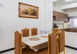 uma sala de jantar com uma mesa e cadeiras numa cozinha em Shah Alam Golden Homestay 4 Rooms, 3 Bathrooms Seksyen 7 near uitm icity em Shah Alam