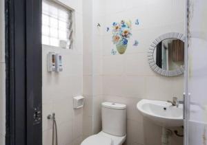 a white bathroom with a toilet and a sink at Shah Alam Golden Homestay 4 Rooms, 3 Bathrooms Seksyen 7 near uitm icity in Shah Alam +21 photos