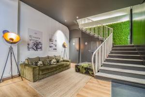ein Wohnzimmer mit einem Sofa und einer Treppe in der Unterkunft Glaner Hotel Cafe in Andorra la Vella