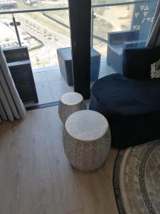 a living room with two stools and a couch at Ellipse Apartment, Lush Hideaway in Midrand
