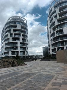 two tall buildings next to a parking lot at Ellipse Apartment, Lush Hideaway in Midrand