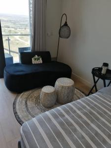 a living room with a bed and a couch at Ellipse Apartment, Lush Hideaway in Midrand