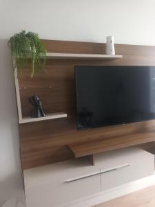 TV de pantalla plana en un centro de entretenimiento de madera en Ellipse Apartment, Lush Hideaway, en Midrand