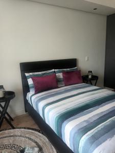 a bedroom with a large bed with red pillows at Ellipse Apartment, Lush Hideaway in Midrand