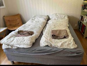a bed with two blankets on it in a room at Bjørn og Jasmins plass in Lærdalsøyri