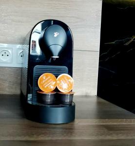 a coffee maker with two oranges on a table at Rynek 23 LUX, apartament z widokiem na ratusz , parking free pod domem in Gliwice +12 photos