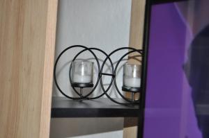 a candle holder with two glasses on a shelf at Apartman Kućica - besplatan parking Smederevo in Smederevo