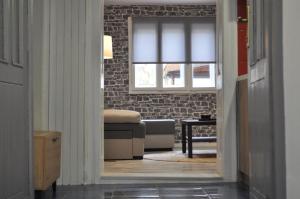 - un salon avec un canapé et une fenêtre dans l'établissement Apartman Kućica - Smederevo, à Smederevo