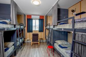 a room with four bunk beds and a chair at Jasper Downtown Hostel in Jasper