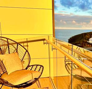 a balcony with two chairs and a view of the ocean at 34 Cliff Edge 2nd floor Newquay luxury sea-view residence in Newquay