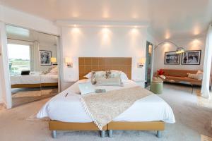 a bedroom with a large bed with a laptop on it at Hôtel La Marine in Barneville-Carteret