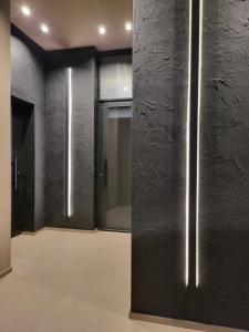 een kamer met zwarte muren en een hal met glazen schuifdeuren bij Dimora Minelli Suites in Monopoli