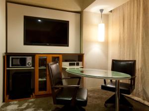 a room with a table and chairs and a tv at The Royal Park Hotel Iconic Tokyo Shiodome in Tokyo