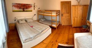 a bedroom with two bunk beds and a wooden floor at Chalupa Zlíčko in Vysoká Srbská +20 photos