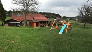 a group of children playing on a playground in a field at Chalupa Zlíčko in Vysoká Srbská