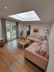 a living room with two couches and a skylight at Holiday home De Waterput in Bergen NH in Bergen
