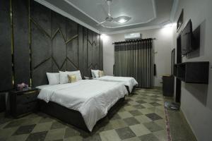 um quarto com uma cama grande e uma televisão em Karachi Guest House Johar em Carachi