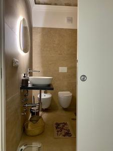 ein Bad mit einem Waschbecken und einem WC in der Unterkunft Bien-être Exclusive Apartment in Taranto