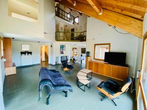 ein Wohnzimmer mit Möbeln und einem Flachbild-TV in der Unterkunft Superbe Maison d’Architecte au cœur du Vercors in Autrans