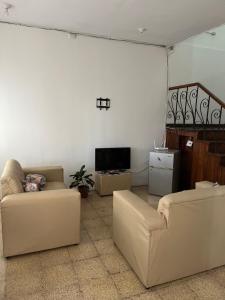 a living room with two couches and a tv at El Parque Bed and Breakfast in Alajuela
