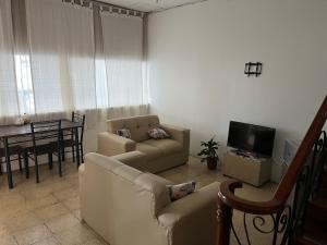 un soggiorno con divano e tavolo di El Parque Bed and Breakfast a Alajuela