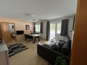 a living room with a black couch and a table at Ferienwohnung Höllrigl in Sankt Leonhard im Pitztal