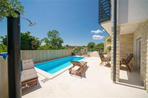 a patio with chairs and a swimming pool at Apartmani Drage in Drage