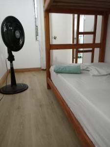 1 dormitorio con ventilador junto a una cama en Estadio APARTE HOTEL 203 en Medellín