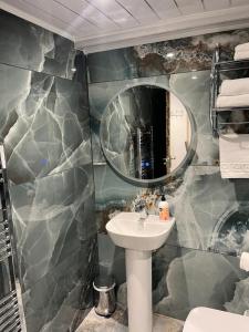 een badkamer met een wastafel en een spiegel bij Poachers Pocket Seaview in Bacton