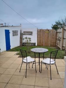 dos sillas y una mesa y una mesa y sillas en Plage et commerces à pieds ! Gîte Eugène, en Saint-Hilaire-de-Riez