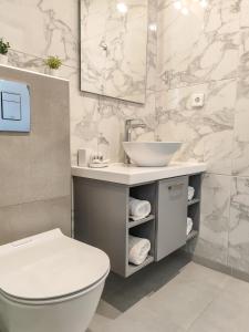 a bathroom with a white toilet and a sink at Anna and Jimmy's in Skiathos