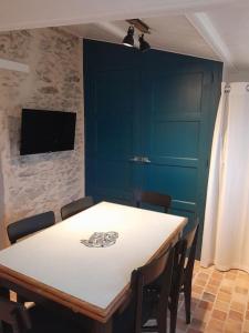 Un comedor con una mesa con sillas y un televisor. en Plage et commerces à pieds ! Gîte Eugène, en Saint-Hilaire-de-Riez 16 fotos más