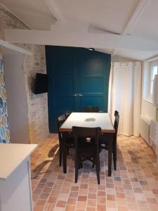 Un comedor con una mesa y sillas en una habitación. en Plage et commerces à pieds ! Gîte Eugène, en Saint-Hilaire-de-Riez