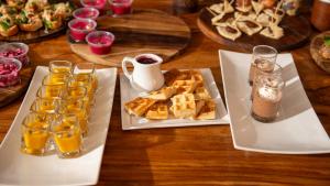 a table with two white plates of food and drinks at Casa Oro Eco Hostel in San Juan del Sur