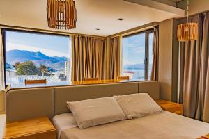 a bedroom with a bed in front of a large window at Miralejos in Ushuaia