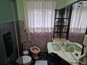 baño con aseo rosa y lavamanos en B&B Cavaliere, en Milán