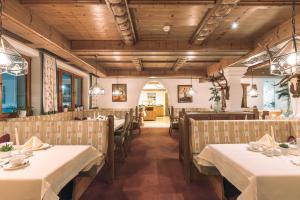 a dining room with white tables and chairs at Hotel Olympia in Ischgl