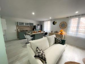 ペズナにあるLa riche histoire de Pézénasの白いソファとキッチンのあるリビングルーム