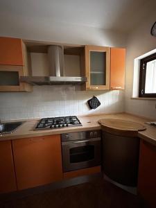 een keuken met oranje kasten en een fornuis met oven bij Appartamento in centro a Spoleto in Spoleto