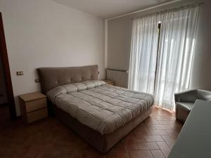 a bedroom with a bed and a chair and a window at Appartamento in centro a Spoleto in Spoleto