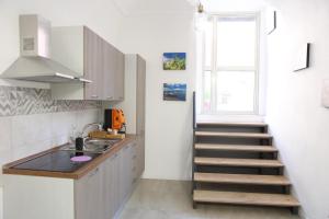 a kitchen with a staircase leading up to a window at Boutique Rooms B&B in Catania