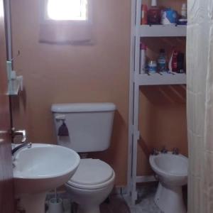a bathroom with a white toilet and a sink at La casita en San Miguel del Monte in San Miguel del Monte