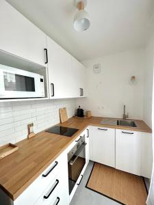 eine Küche mit weißen Schränken und einem Waschbecken in der Unterkunft Bel appartement lumineux résidentiel proche de Paris in Ivry-sur-Seine