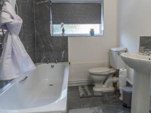 a bathroom with a tub and a toilet and a sink at Pass the Keys Beautiful Home near City Centre in Nottingham