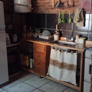 una cucina con lavandino e piano cottura forno superiore di La casita en San Miguel del Monte a San Miguel del Monte