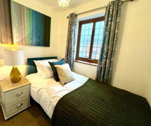 een slaapkamer met een bed en een raam bij 3br House Ossett-Wakefield, Free Parking 3 cars Wi Fi Long stays in Wakefield