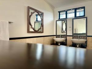 a bathroom with two sinks and two mirrors at Meerendahl Luxury Apartments at Tyger Lake in Cape Town +37 photos