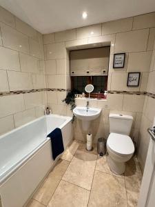 La salle de bains est pourvue d'une baignoire, de toilettes et d'un lavabo. dans l'établissement 3br House Ossett-Wakefield, Free Parking 3 cars Wi Fi Long stays, à Wakefield